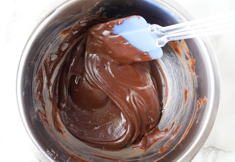 a stainless steel bowl and a spatula with melted chocolate